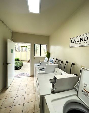 a laundry room with two washing machines and two sinks
